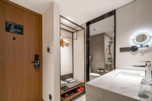 a bathroom with a sink and a mirror at Atour Hotel Fuzhou Jinshan Aegean Sea in Fuzhou