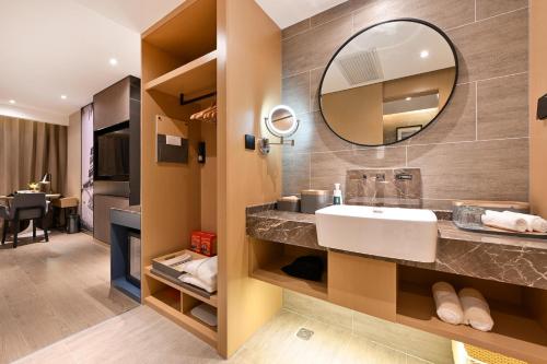 W łazience znajduje się umywalka i lustro. w obiekcie Atour S Hotel Beijing Anzhen w Pekinie