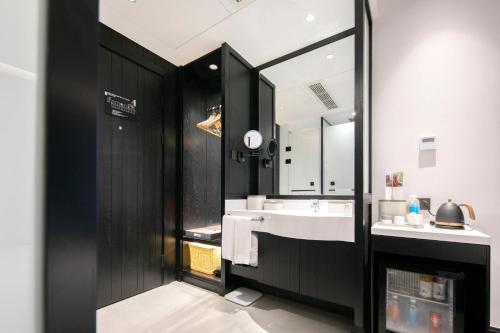 een badkamer met een wastafel en een spiegel bij Atour X Hotel Hangzhou West Lake Wulin Plaza Yan'an Road in Hangzhou
