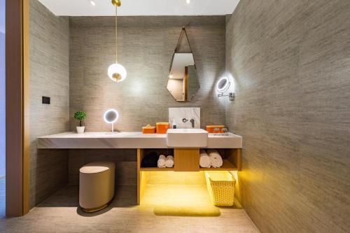 a bathroom with a sink and a counter with a sink at Atour Basketball Hotel Rizhao Municipal Government Wanpingkou in Rizhao