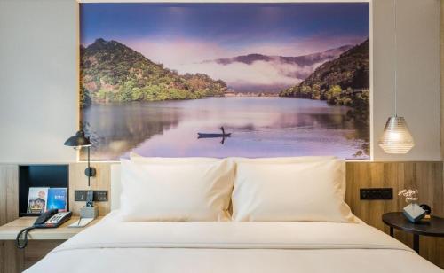 une chambre avec une peinture d'un lac avec un bateau. dans l'établissement Atour Hotel Zhejiang University East Fengqi Road, à Hangzhou