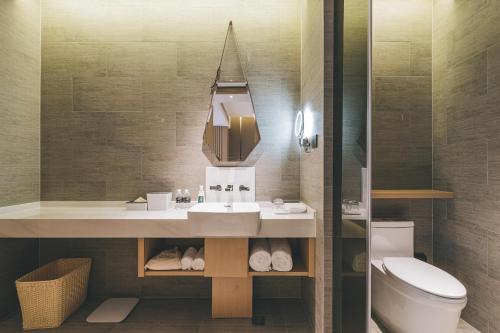 a bathroom with a sink and a toilet and a mirror at Atour Hotel North Bund Shanghai in Shanghai