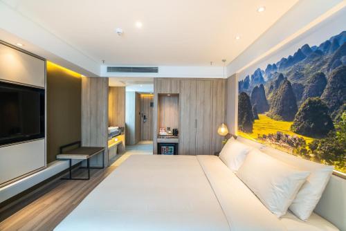 ein Hotelzimmer mit einem großen Bett und einem TV in der Unterkunft Atour Hotel Guiyang Convention and Exhibition Center in Guiyang