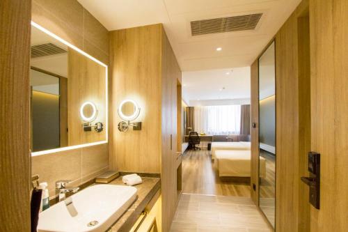 y baño con lavabo y espejo. en Atour Hotel Shenyang Hunnan Olympic Sports Center, en Shenyang