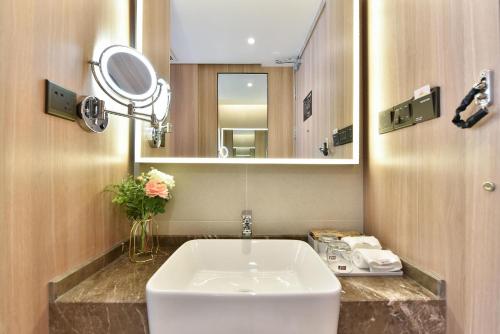 a bathroom with a sink and a mirror at Atour Light Hotel Shenyang Tiexi Plaza Wanxianghui in Shenyang