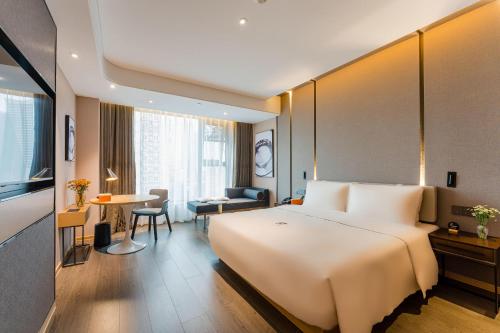 een hotelkamer met een groot bed en een woonkamer bij Atour Hotel Chongqing Nanping Pedestrain Street in Chongqing