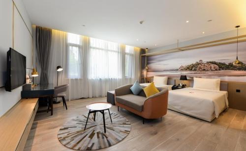 a hotel room with a bed and a couch at Atour Hotel Zhoudun Beidaihe Qinhuangdao in Qinhuangdao