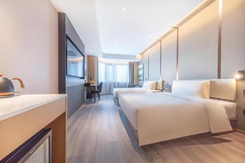 a hotel room with two beds and a desk at Atour Hotel Tianjin Marina Third Street MSD in Binhai