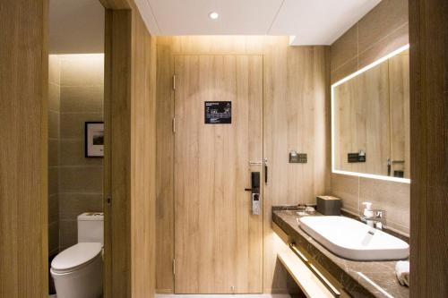a bathroom with a sink and a toilet at Atour Hotel Shenyang Hunnan Olympic Sports Center in Shenyang