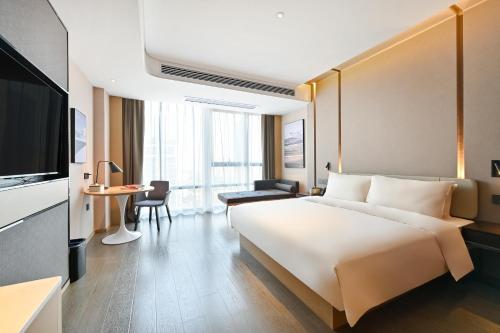 a hotel room with a large bed and a television at Atour Hotel Fuzhou Diamond Plaza in Fuzhou