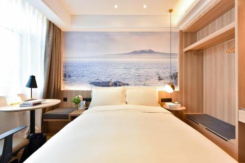 a bedroom with a large bed and a view of the ocean at Atour Light Hotel Shenyang Tiexi Plaza Wanxianghui in Shenyang