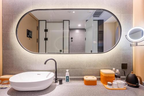 bagno con lavandino e grande specchio di Atour Hotel Shanghai World Expo West Gaoke Road a Shanghai