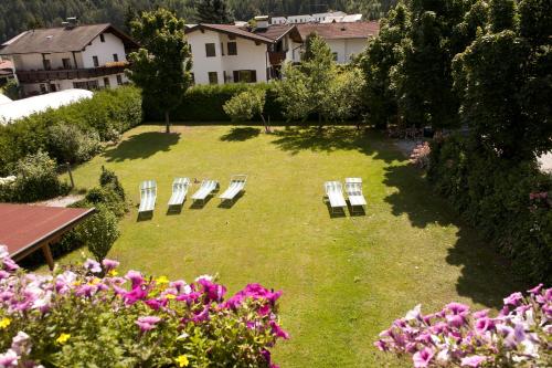 a group of chairs sitting in a yard with flowers at Alpenhotel Tirolerhof in Fulpmes