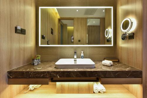 een badkamer met een wastafel en een grote spiegel bij Atour Hotel Zhongguancun Yongfeng Base Beijing in Beijing