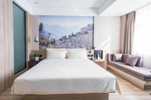 a bedroom with a large white bed and a couch at Atour Hotel Yingxiongshan Road Jinan in Jinan