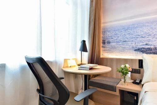 a hotel room with a desk and a bed and a table at Atour Light Hotel Shenyang Tiexi Plaza Wanxianghui in Shenyang