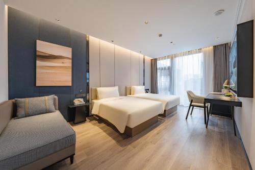 a bedroom with a bed and a desk and a couch at Atour Hotel Shanghai Zhangjiang Park Science City in Shanghai