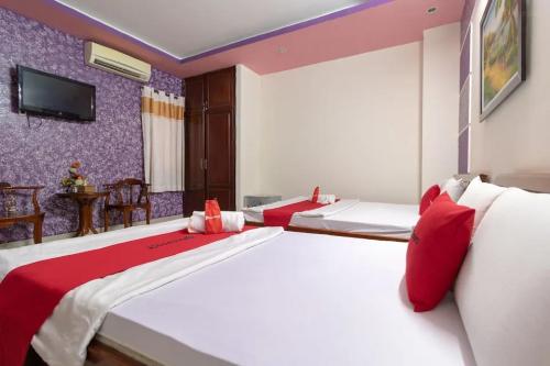 een slaapkamer met 2 bedden en een tv aan de muur bij Sao Phương Thảo Hotel - 140 Lê Thiệt - by Bay Luxury in Ho Chi Minh-stad