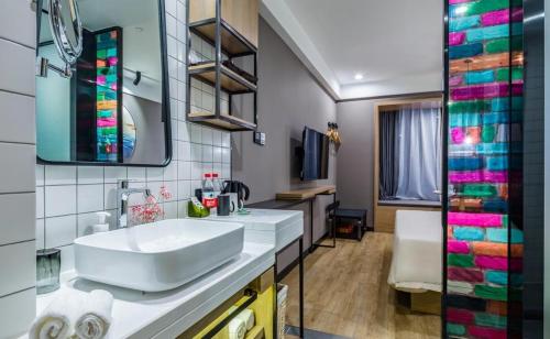 a bathroom with a white sink and a mirror at Atour Light Hotel Shandong Road CBD Qingdao in Qingdao