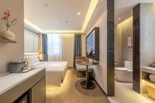 深セン市にあるAtour S Hotel Shenzhen Futian Portのベッドとトイレ付きのホテルルーム