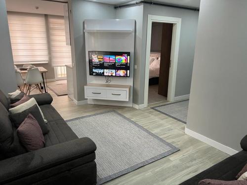 ein Wohnzimmer mit einem Sofa und einem Flachbild-TV in der Unterkunft Cosy suites hotel in Antalya