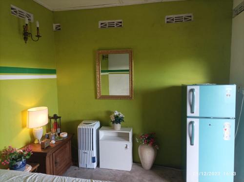a room with a green wall with a refrigerator at Farmhouse in Jaffna District 