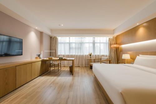 Habitación de hotel con cama y escritorio en Atour X Hotel Wuxi New Zone Gelunbu Plaza, en Wuxi