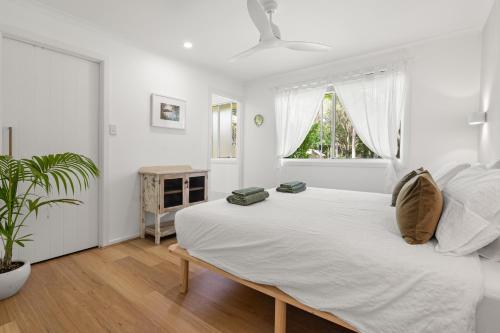 サフォーク・パークにあるSuffolk Park Palms - Relaxing home minutes to Byronの白いベッドルーム(大型ベッド1台、窓付)