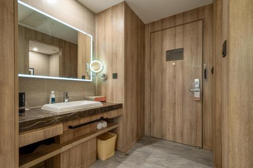 un bagno con lavandino e specchio di Atour Hotel (Shanghai International Tourism and Resorts Zone XiuYan Road) a Shanghai