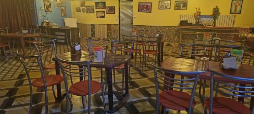 a room with tables and chairs in a restaurant at Jayara Resort And Cafe in Barkot