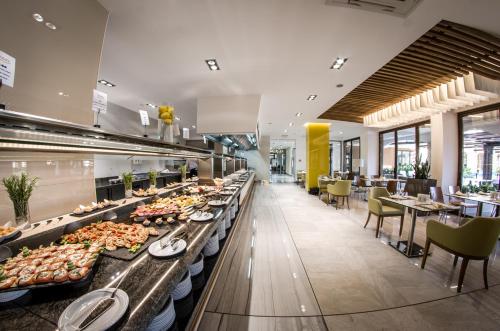 Premier Fort Beach Hotel في سفيتي فلاس: طابور بوفيه في مطعم به طاولات وكراسي