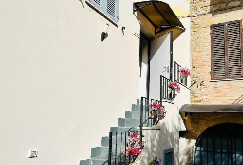 ペトリニャーノにあるAssisi, Angolo di Matildeの階段と窓の花々のある建物