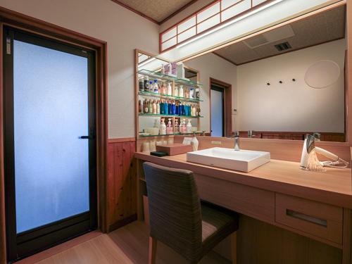 a bathroom with a sink and a large mirror at Ryokusuitei in Kamogawa