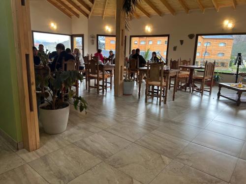 un ristorante con persone sedute a tavoli e sedie di Hosteria Koonek a El Chalten