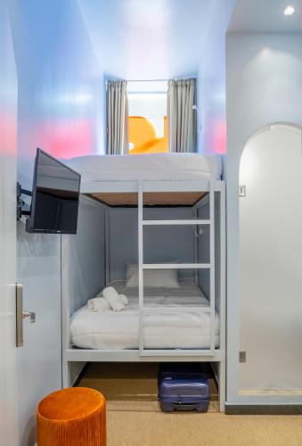a room with a bunk bed with a tv and a stool at Cabins Sleeping Mets in Athens