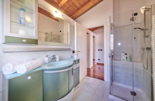 ein Bad mit einem Waschbecken und einer Dusche in der Unterkunft Balcony Lake View Apartment in Lierna