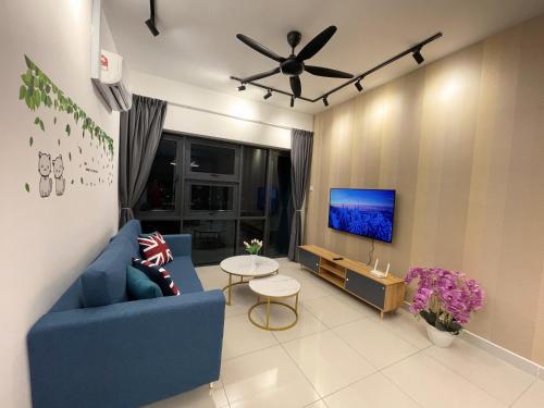 a living room with a blue couch and a tv at Pacific Tower Petaling Jaya Near Jaya One, University Malaya, Columbia Hospital By My Homez in Petaling Jaya