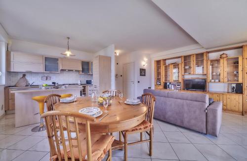 a kitchen and dining room with a wooden table and chairs at Balcony Lake View Apartment in Lierna