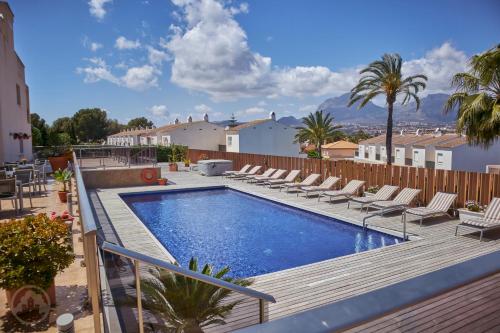 a swimming pool with chaise lounge chairs on a deck at Albir Palace in Albir