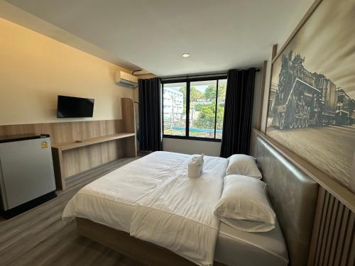 una camera da letto con un letto e una televisione di PhunPhin Station พุนพินสเตชั่น a Ban Tha Kham