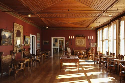 ein Zimmer mit Tischen und Stühlen in einem Zimmer mit roten Wänden in der Unterkunft Kviknes Hotel in Balestrand