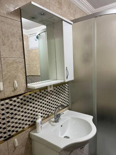 La salle de bains est pourvue d'un lavabo et d'un miroir. dans l'établissement Квартира с кухней и балконом (№2), à Samanlı