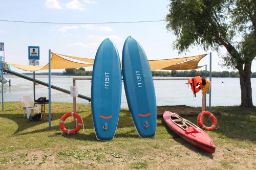 a group of surfboards on display next to a body of water at Tisza-tó Apartmanpark in Kisköre