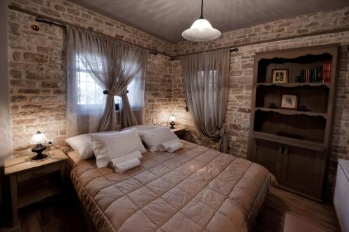 a bedroom with a large bed and brick walls at Roptro in Doliana