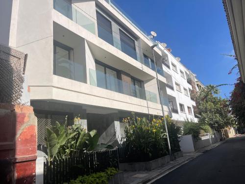 a white building with a fence next to a street at Magic Appartement Luxury Gauthier 04 in Casablanca