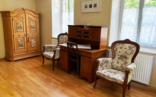 Pokój z drewnianym biurkiem z 2 krzesłami w obiekcie Deutsches Haus w mieście Waal
