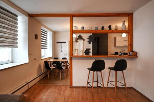 a kitchen with black chairs and a counter in a room at Alte Schule in Bad Brambach