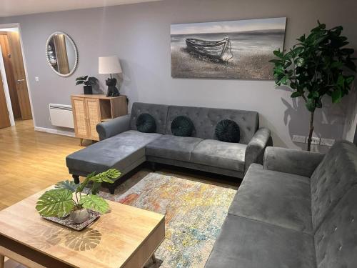 a living room with a couch and a table at Newly Refurbished One Bedroom Apartment Swindon in Swindon