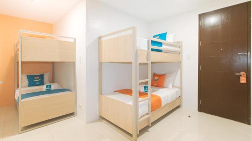 two bunk beds in a small room at Sans Hotel at One JD Place Makati by RedDoorz in Manila