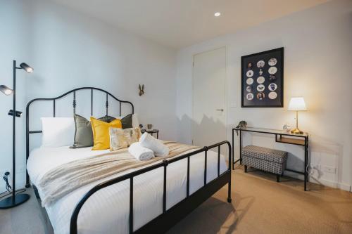 sypialnia z dużym łóżkiem z żółtymi poduszkami w obiekcie Chic 1-Bed Apt in Melbourne with parking near CBD w Melbourne